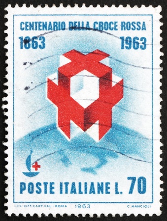 ITALY - CIRCA 1963: a stamp printed in the Italy shows Crosses and Centenary Emblem on Globe, Centenary, of Founding International Red Cross, circa 1963のeditorial素材