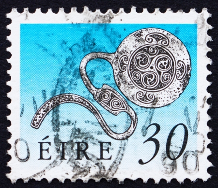 IRELAND - CIRCA 1990: a stamp printed in the Ireland shows Enamel Latchet Brooch, Art Treasure of Ireland, circa 1990のeditorial素材