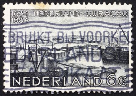NETHERLANDS - CIRCA 1934: a stamp printed in the Netherlands shows Willemstad Harbor, Tercentenary of Curacao, Lesser Antilles, circa 1934のeditorial素材