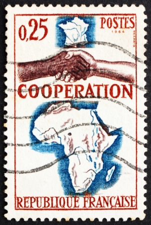 FRANCE - CIRCA 1964: a stamp printed in the France shows French-African Handshake, circa 1964のeditorial素材