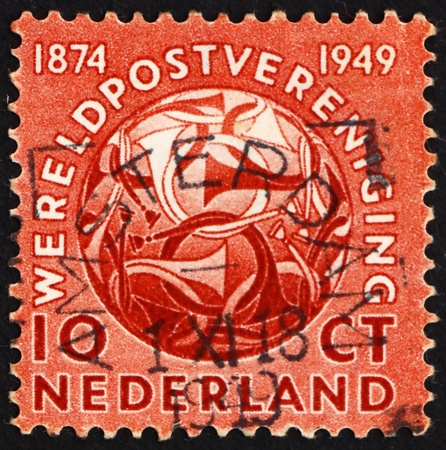 NETHERLANDS - CIRCA 1949: a stamp printed in the Netherlands shows Post Horns Entwined, 75th Anniversary of the UPU, circa 1949のeditorial素材