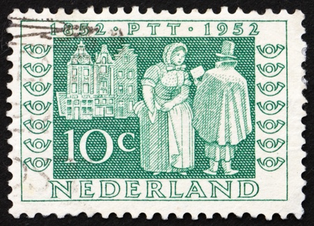 NETHERLANDS - CIRCA 1952: a stamp printed in the Netherlands shows Mail Delivery 1852,  Centenary of Dutch Postage Stamps, circa 1952のeditorial素材