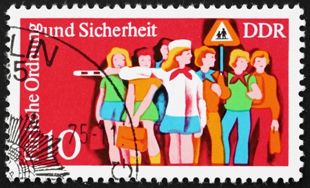 GDR - CIRCA 1975: a stamp printed in GDR shows Children and Child Crossing Guard, Traffic Police Serving and Instructing the Public, circa 1975のeditorial素材