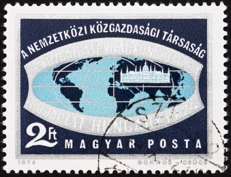 HUNGARY - CIRCA 1974: a stamp printed in the Hungary shows Emblem of 4th Congress of Economist, Budapest, Globe and Hungarian Parliament, circa 1974のeditorial素材