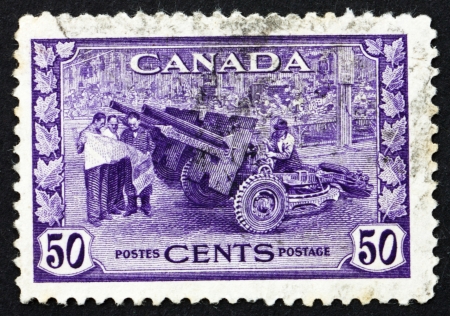 CANADA - CIRCA 1942: a stamp printed in the Canada shows Cannon, Munitions Factory, circa 1942のeditorial素材