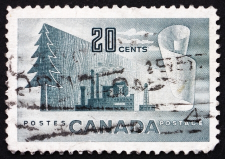 CANADA - CIRCA 1952: a stamp printed in the Canada shows Symbols of Newsprint Paper Production, From Tree to Paper, circa 1952のeditorial素材
