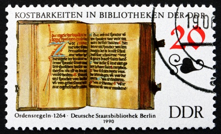 GDR - CIRCA 1990: a stamp printed in GDR shows Rules of an Order, Book from 1264, Treasures in the German State Library, Berlin, circa 1990のeditorial素材