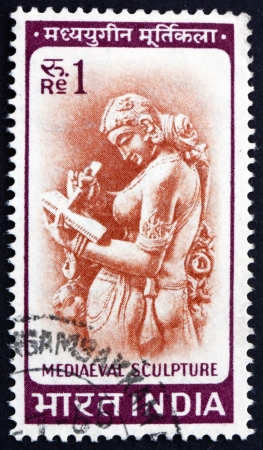 INDIA - CIRCA 1966: a stamp printed in India shows Woman Writing Letter, Chandella Carving, 11th Century, circa 1966のeditorial素材