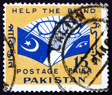 PAKISTAN - CIRCA 1965: a stamp printed in Pakistan shows Eyeglasses and Book, Aid for the Blind, circa 1965のeditorial素材