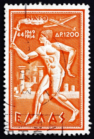 GREECE - CIRCA 1954: a stamp printed in the Greece shows Torchbearer, 5th Anniversary of the Signing of the North Atlantic Treaty, circa 1954のeditorial素材