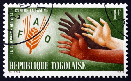 TOGO - CIRCA 1963: a stamp printed in Togo shows Hands Reaching for FAO Emblem, FAO Freedom from Hunger Campaign, circa 1963のeditorial素材