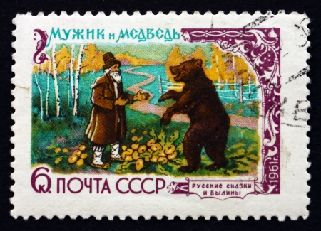 RUSSIA - CIRCA 1961: a stamp printed in the Russia shows The Peasant and the Bear, Fairy Tale, circa 1961のeditorial素材