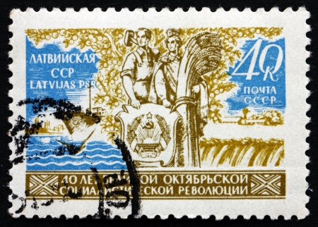 RUSSIA - CIRCA 1957: a stamp printed in the Russia shows Couple, Sea and Field, 40th Anniversary of the October Revolution, circa 1957のeditorial素材