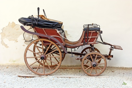 Old wooden carriage in front of wallの写真素材