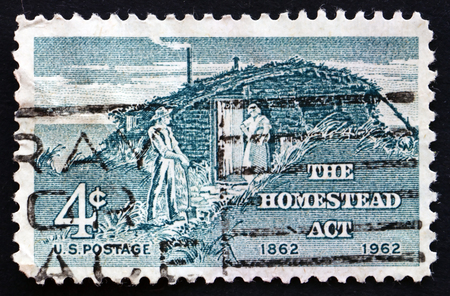 UNITED STATES OF AMERICA - CIRCA 1962: a stamp printed in the USA shows Sod Hut and Settlers, Homestead Act Centenary, circa 1962のeditorial素材