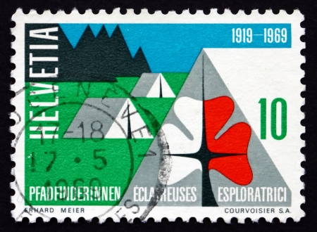 SWITZERLAND - CIRCA 1969: a stamp printed in the Switzerland shows Swiss Girl Scouts' Emblem and Camp, 50th Anniversary of Swiss Girl Scouts, circa 1969のeditorial素材