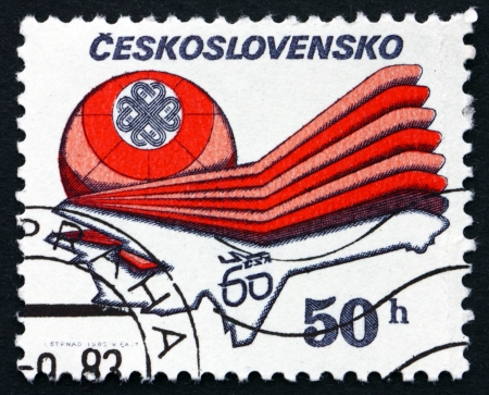 CZECHOSLOVAKIA - CIRCA 1983: a stamp printed in the Czechoslovakia shows Emblem and Aircraft, World Communications Year, circa 1983のeditorial素材