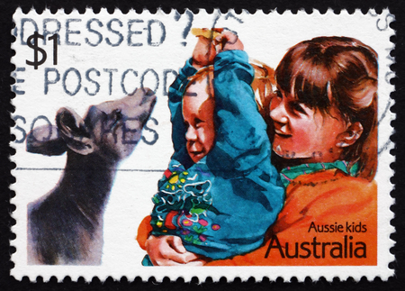 AUSTRALIA - CIRCA 1987: a stamp printed in the Australia shows Playing with a Joey, Children, circa 1987のeditorial素材