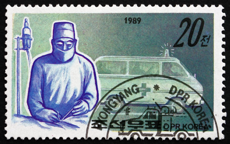 NORTH KOREA - CIRCA 1989: a stamp printed in North Korea shows Surgeon and Ambulance, Emergency Medical Service, circa 1989のeditorial素材