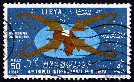 LIBYA - CIRCA 1965: a stamp printed in Libya shows Map of Africa with Libya, Fair Emblem, 4th International Fair, Tripoli, circa 1965のeditorial素材