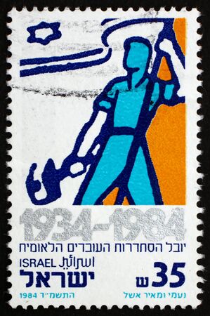 ISRAEL - CIRCA 1984: a stamp printed in the Israel shows Worker with Flag, National Labor Federation, 50th Anniversary, circa 1984のeditorial素材