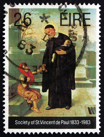 IRELAND - CIRCA 1983: A stamp printed in Ireland shows Priest and Children, Society of St. Vincent de Paul, Sesquicentennial, Catholic Voluntary Organization, circa 1983のeditorial素材