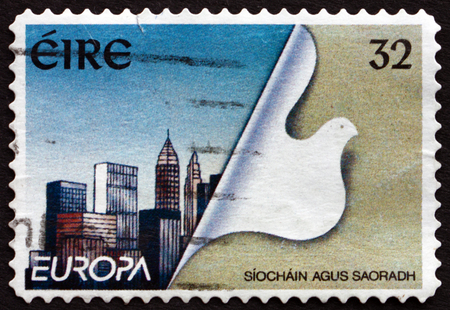 IRELAND - CIRCA 1995: A stamp printed in Ireland shows Stylized Dove and Reconstructed City, Peace and Freedom, circa 1995のeditorial素材