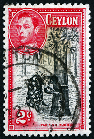 SRI LANKA - CIRCA 1938: a stamp printed in Sri Lanka shows Tapping Rubber Tree, circa 1938のeditorial素材