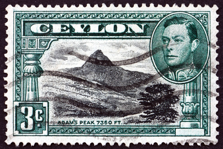 SRI LANKA - CIRCA 1938: a stamp printed in Sri Lanka shows View of Adam's Peak and Portrait of King George VI, circa 1938のeditorial素材