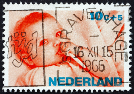 NETHERLANDS - CIRCA 1966: a stamp printed in Netherlands shows Infant, circa 1966のeditorial素材