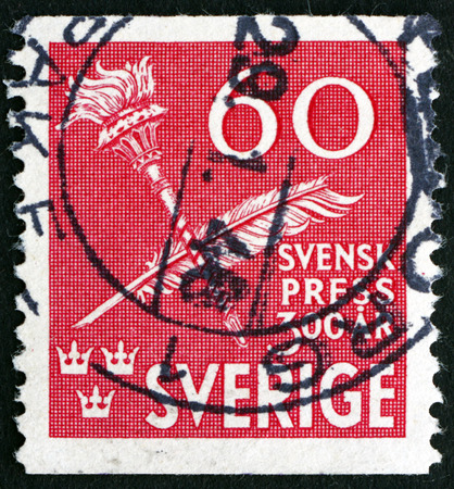 SWEDEN - CIRCA 1945: a stamp printed in Sweden shows Torch and Quill Pen, Tercentenary of Swedish Press, circa 1945のeditorial素材