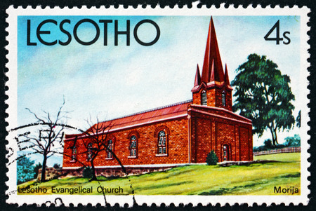 LESOTHO - CIRCA 1980: a stamp printed in the Lesotho shows Lesotho Evangelical Church, Morija, circa 1980のeditorial素材