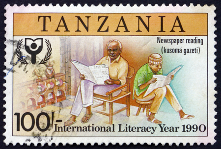 TANZANIA - CIRCA 1991: a stamp printed in Tanzania dedicated to International literacy year, reading newspapers, circa 1991のeditorial素材