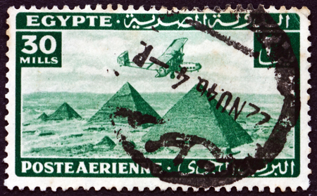 EGYPT - CIRCA 1941: a stamp printed in Egypt shows Airplane over Giza pyramids, circa 1941のeditorial素材