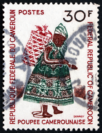 CAMEROON - CIRCA 1970: a stamp printed in Cameroon shows Doll with basket on back, Cameroun puppet, circa 1970のeditorial素材