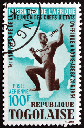 TOGO - CIRCA 1964: a stamp printed in Togo shows African breaking slavery chain, and map, circa 1964のeditorial素材