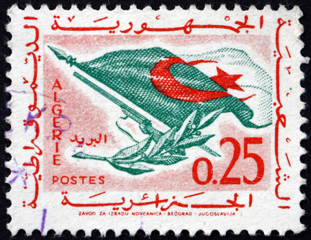 ALGERIA - CIRCA 1963: a stamp printed in Algeria shows flag, rifle and olive branch, circa 1963のeditorial素材