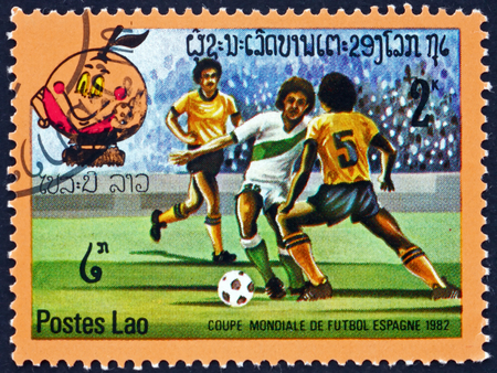 LAOS - CIRCA 1982: a stamp printed in Laos shows soccer players in action, 1982 World Cup Soccer Championships, Spain, circa 1982のeditorial素材
