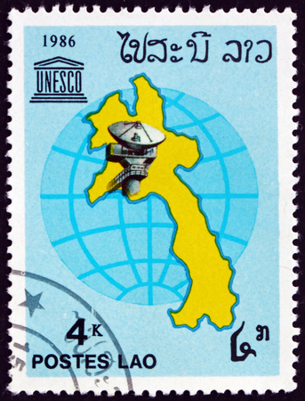 LAOS - CIRCA 1986: a stamp printed in Laos shows satellite dish, map and globe, circa 1986のeditorial素材