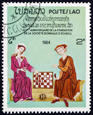 LAOS - CIRCA 1984: a stamp printed in Laos shows chess players, 60th anniversary of the World Chess Federation, circa 1984のeditorial素材