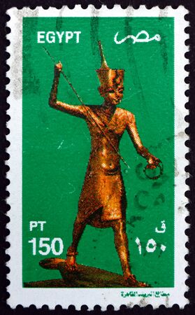 EGYPT - CIRCA 1982: a stamp printed in Egypt shows King Tutankhamen as Harpooner, a Golden Statue of King Tutankahamen, circa 1982のeditorial素材