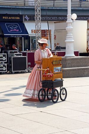 CROATIA ZAGREB, 18 AUGUST 2018: Woman dressed in old-fashioned clothes plays an street organ in centar of Zagreb, touristic attraction, Croatiaのeditorial素材