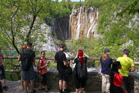CROATIA PLITVICE, 29 APRIL 2018: Group of tourists takes pictures of waterfall in Plitvice Lakes National Park, Croatiaのeditorial素材