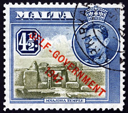 MALTA - CIRCA 1948: a stamp printed in Malta shows Mnajdra temple, is a megalithic temple complex found on the southern coast of Malta, circa 1948のeditorial素材