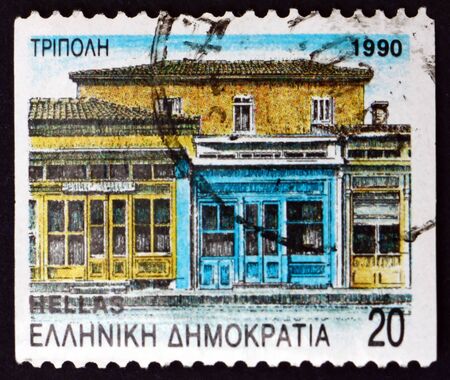 GREECE - CIRCA 1990: a stamp printed in the Greece shows Tripolis, street with neoclassical architecture, department seat, circa 1990のeditorial素材