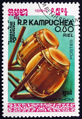 CAMBODIA - CIRCA 1984: a stamp printed in Cambodia shows skor thom, are two-headed barrel drums, Cambodian traditional musical instrument, circa 1984のeditorial素材