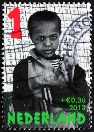 NETHERLANDS - CIRCA 2013: a stamp printed in the Netherlands shows little boy for school blackboard, circa 2013のeditorial素材