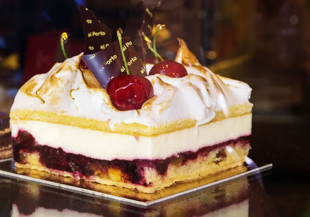 piece of cake with cream and cherries on tableの写真素材