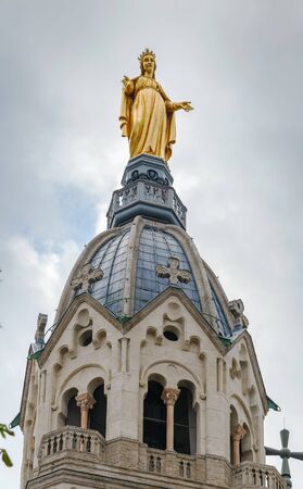 Bell tower of Basilica of Notre-Dame de Fourviere with a gilded statue of the Virgin Mary, Lyon, Franceの写真素材