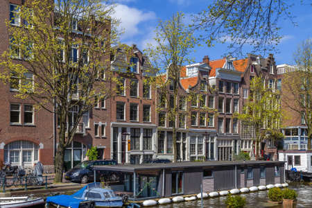 Embankment with historical houses and house on the water in Amsterdam, Netherlandsの写真素材